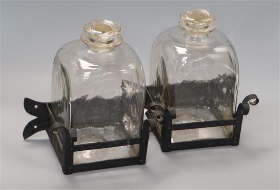 A pair of glass square decanters, on wrought iron stands